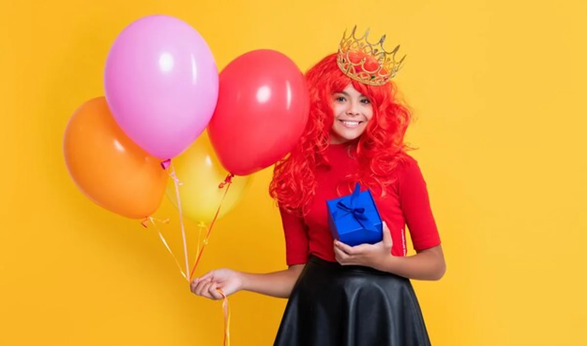 Szczęśliwe dziecko z balonem i pudełkiem na żółtym tle