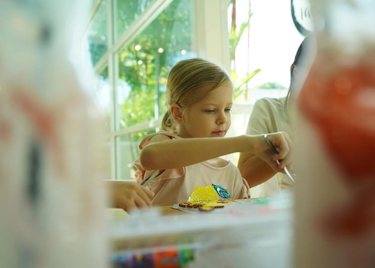 Nauczycielka pomaga dwóm dziewczynom w montażu termo mozaiki