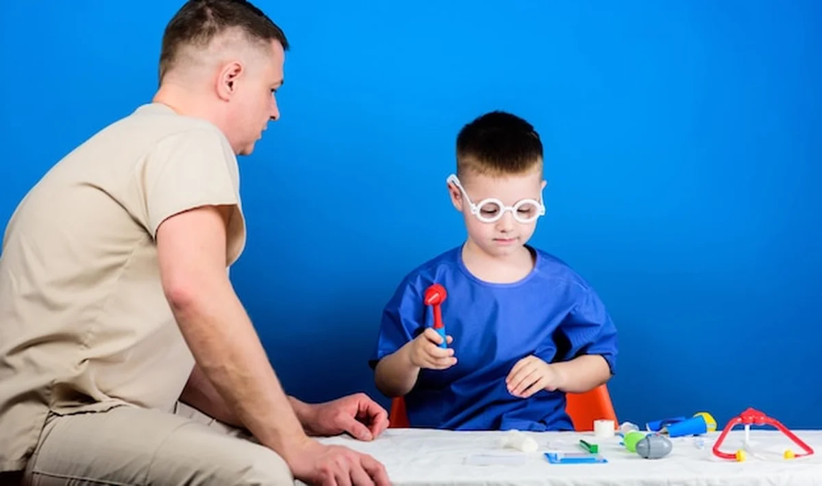 Chłopiec z ojcem lekarzem i narzędziami medycznymi