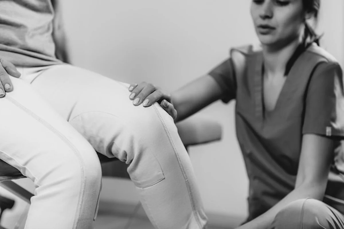 Fizjoterapeuta pracuje z nogą starszą kobietą