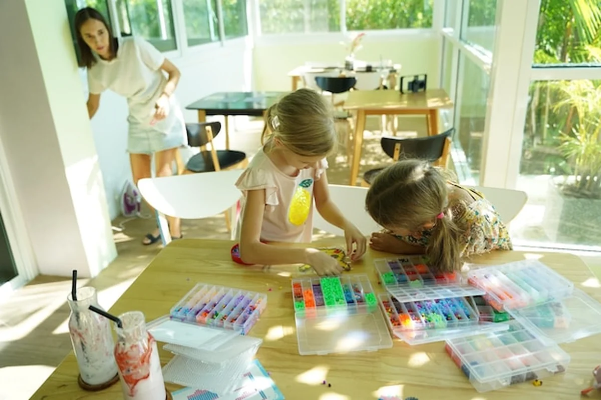 Nauczycielka uczy dwie dziewczyny montować termo mozaikę