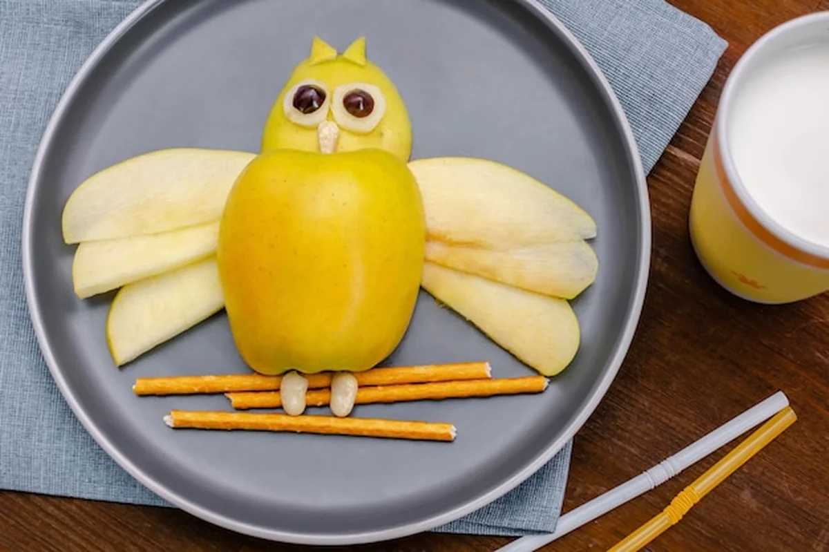 Zabawna przekąska z jabłkiem w kształcie sowy na talerzu