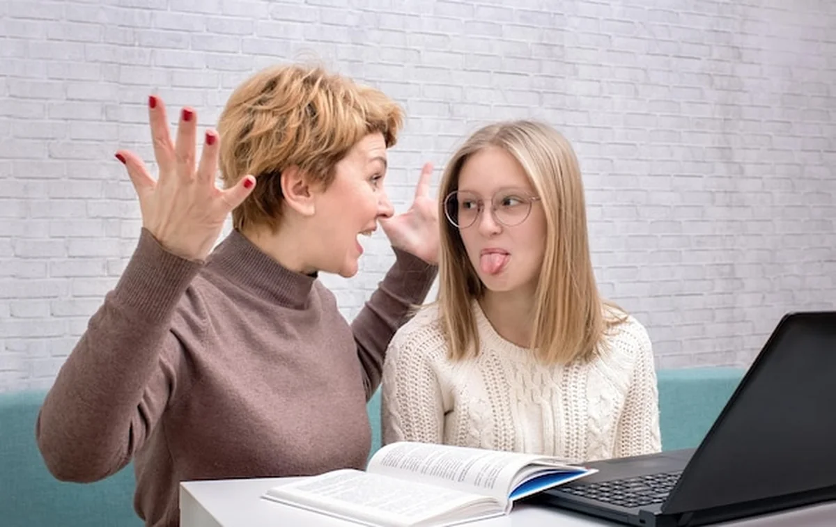 Matka krzyczy na nastoletnią córkę, córka pokazuje język