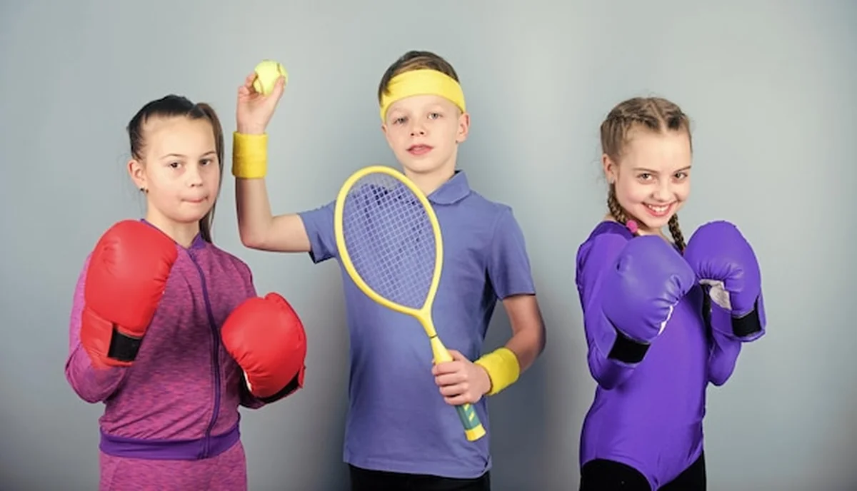 Grupa dzieci z różnymi przyborami sportowymi