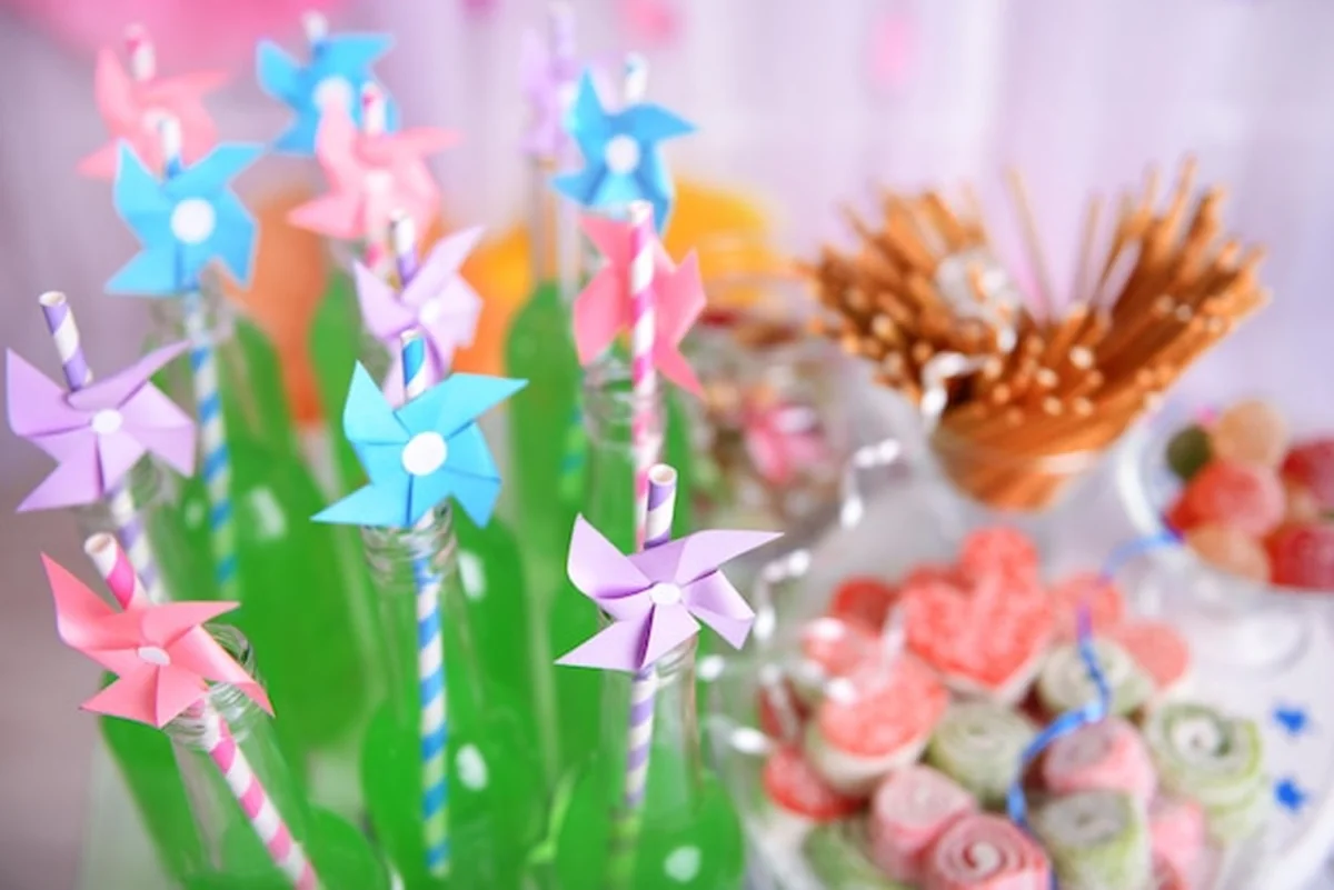 Butelki napojów z słomą i słodyczami na dekoracyjnym tle