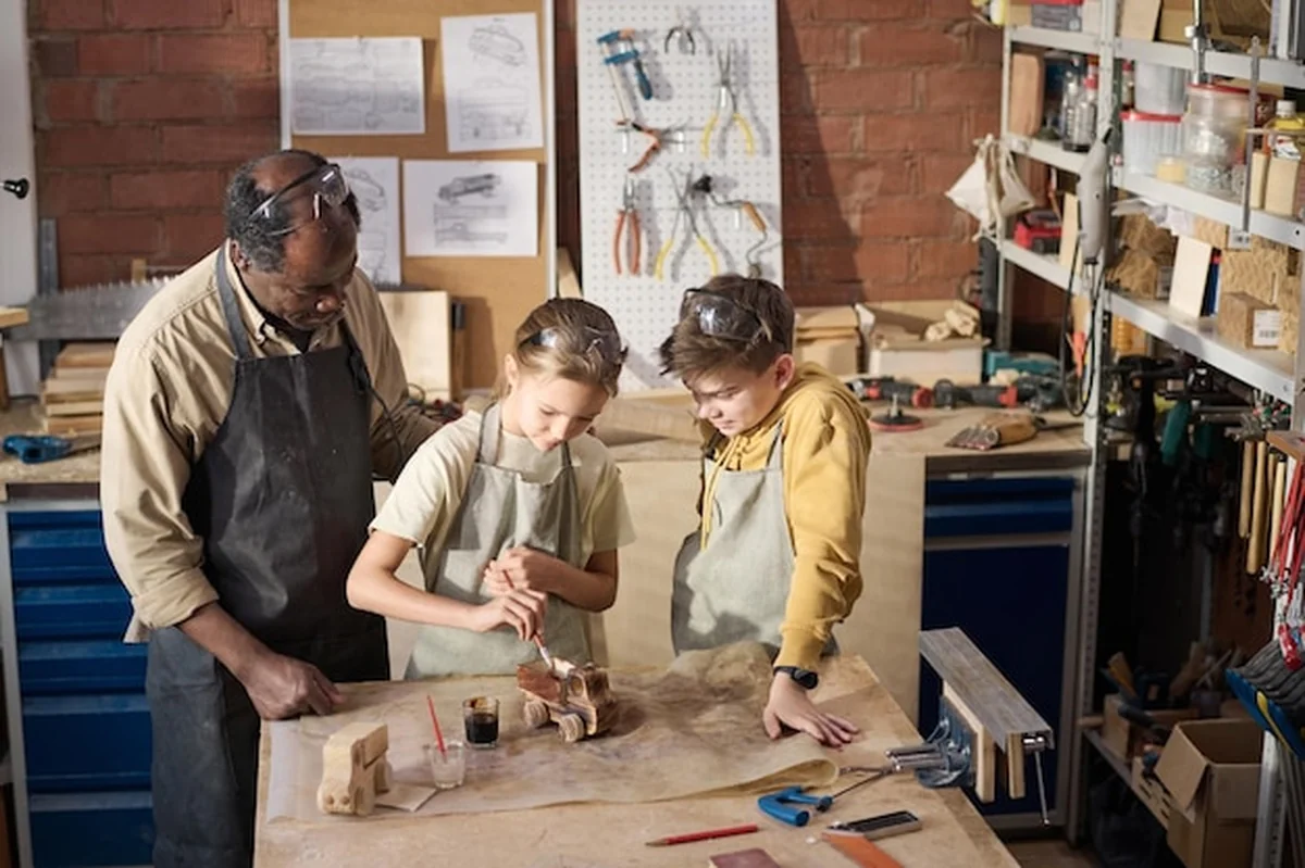 Dwoje dzieci maluje drewniany model zabawki