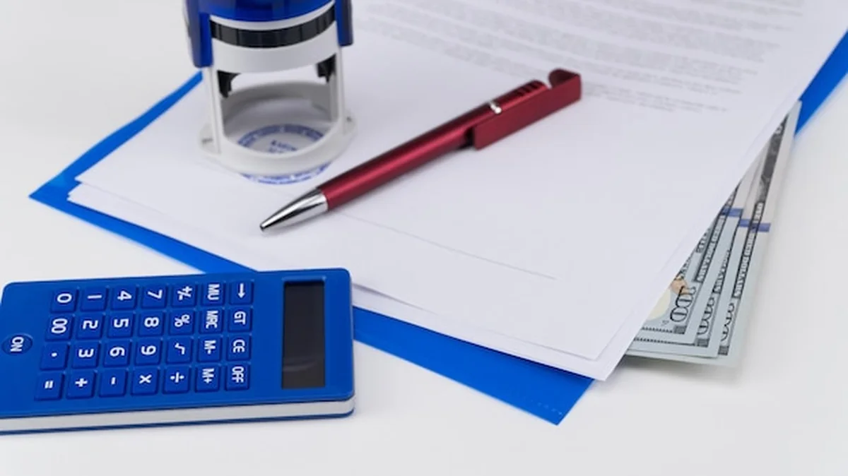 Dolary amerykańskie pod dokumentami obok kalkulatora, pieczątki Łapówka i korupcja