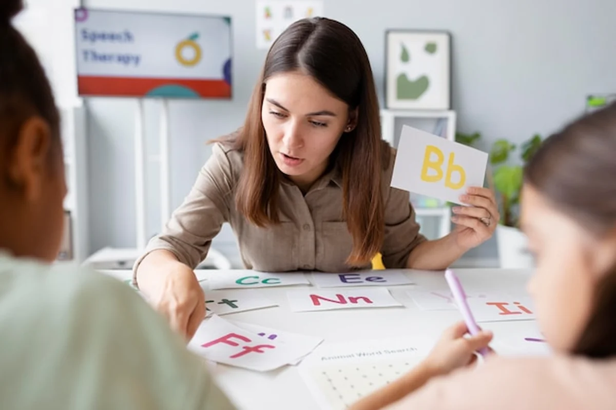 Młoda kobieta robi terapię mowy z dziećmi w klinice