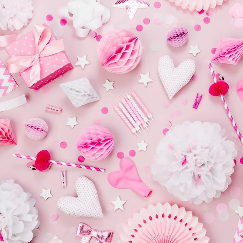 Różowo-białe dekoracje papierowe, pompony, cukierki, serduszka, prezenty i konfetti na przyjęcie dziecięce
