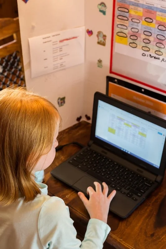 Dziewczynka używająca komputera do pracy szkolnej