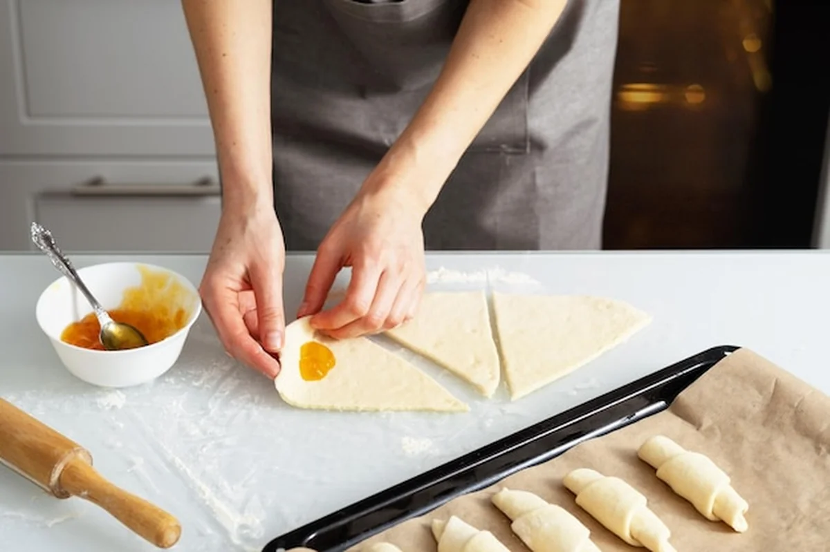 Kobieta w kuchni piecze bajgle z dżemem