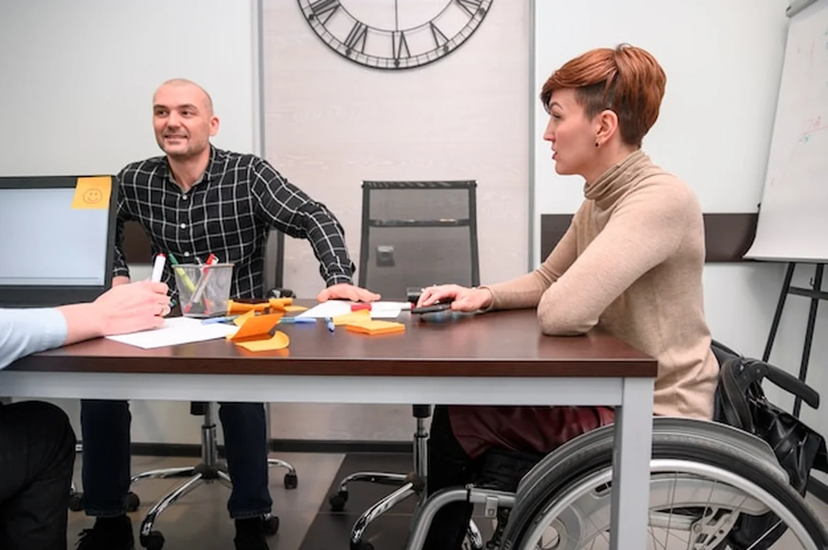 Niepełnosprawna młoda kobieta w biurze przy biurku