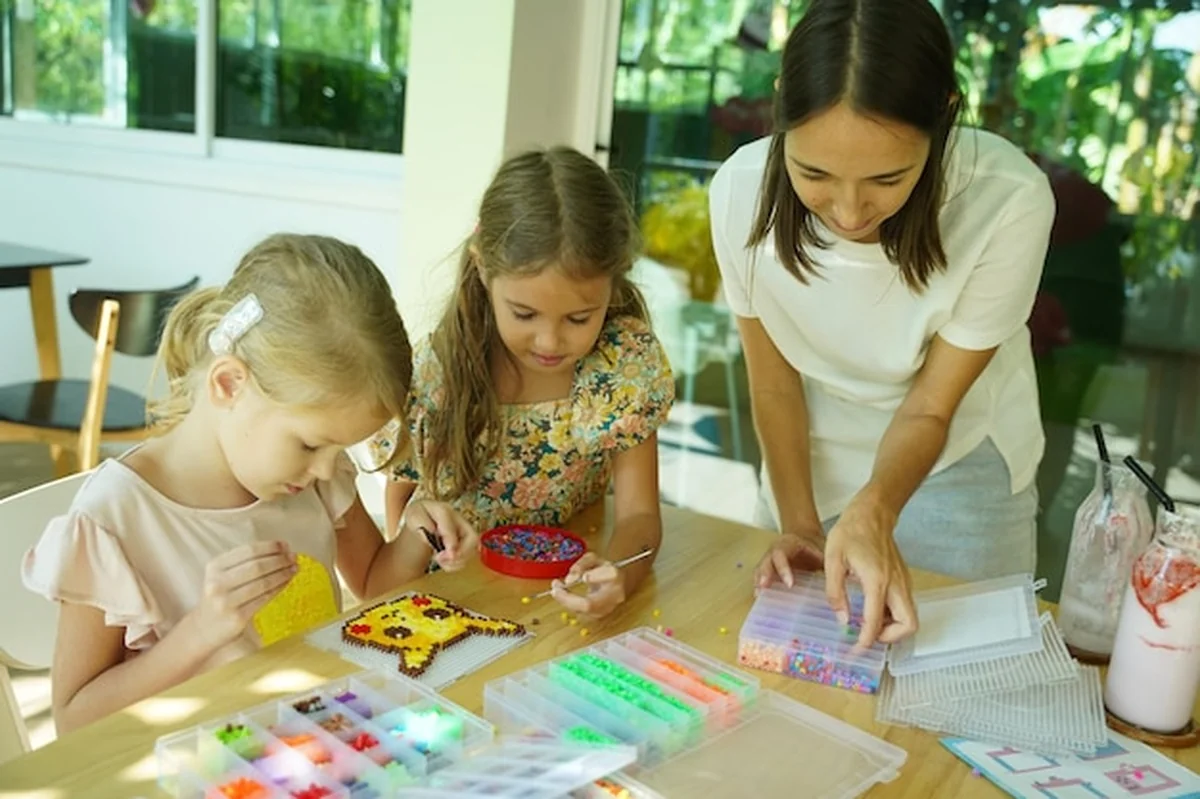 Nauczycielka uczy dwie dziewczyny montować termo mozaikę