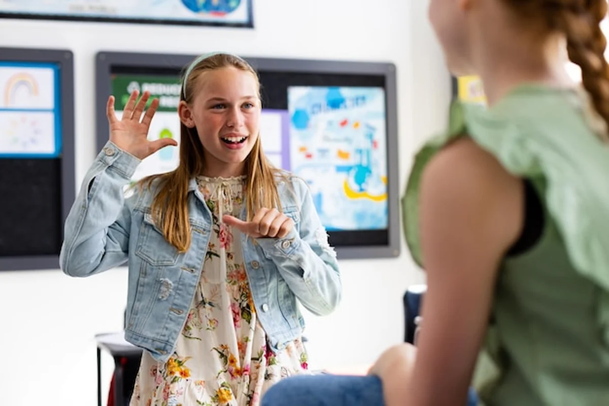 Uczniowie używają języka migowego w klasie szkolnej