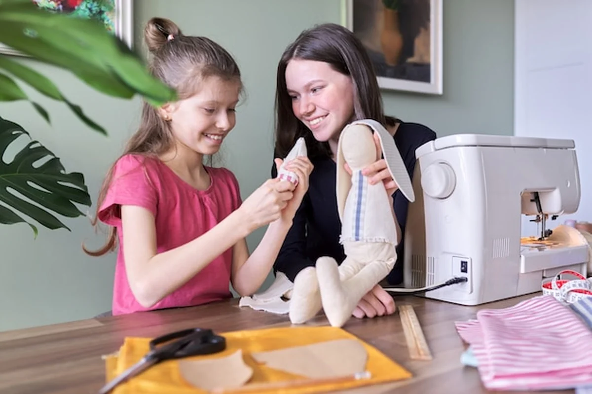 Dzieci szyją lalkę króliczka w domu