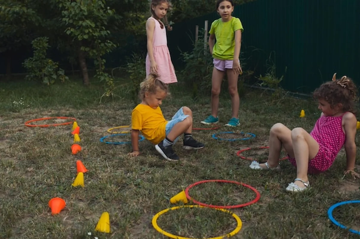 Dzieci bawiące się butelkowym slalomem w ogrodzie